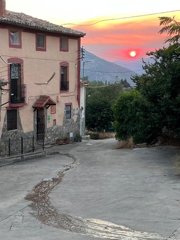 a building with a sunset in the background at La Casonna - Aluenda in El Frasno