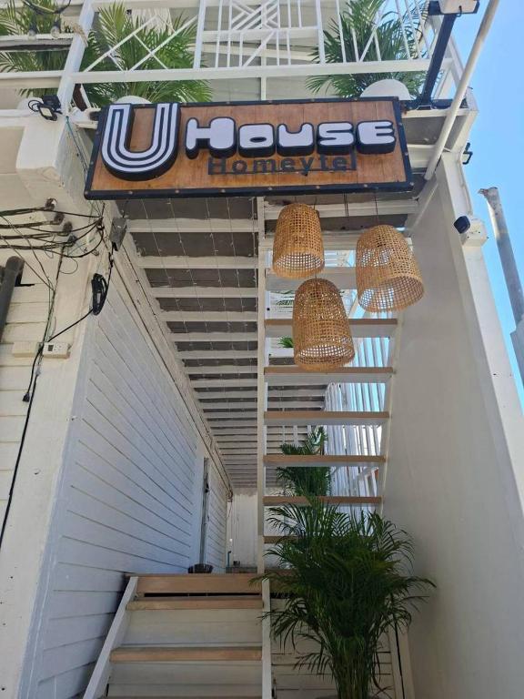 a building with a sign on the side of a stairs at U House Homeytel in Ban Tai