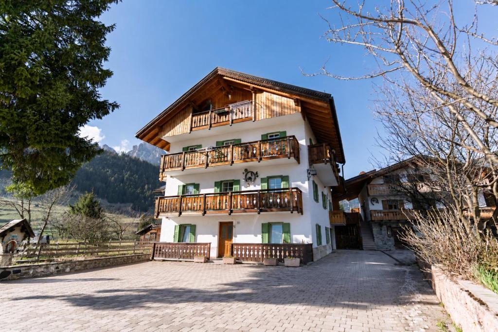 a house in the mountains with a balcony at Appartamenti Pollam by AMA Val di Fassa in Pozza di Fassa