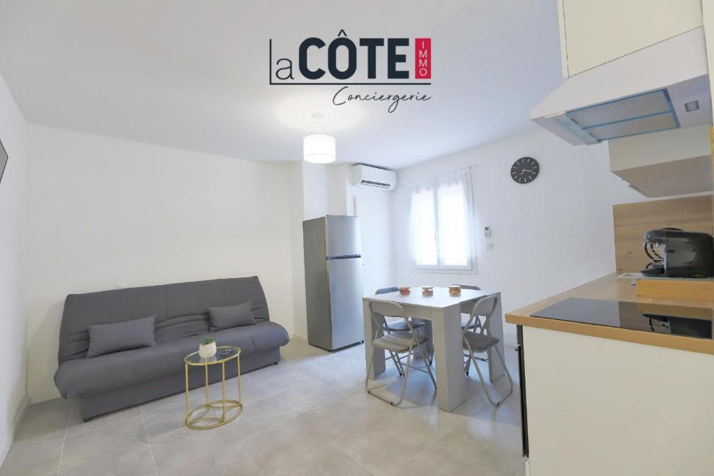 a kitchen and a living room with a couch and a table at Duplex Villebois in Port-de-Bouc