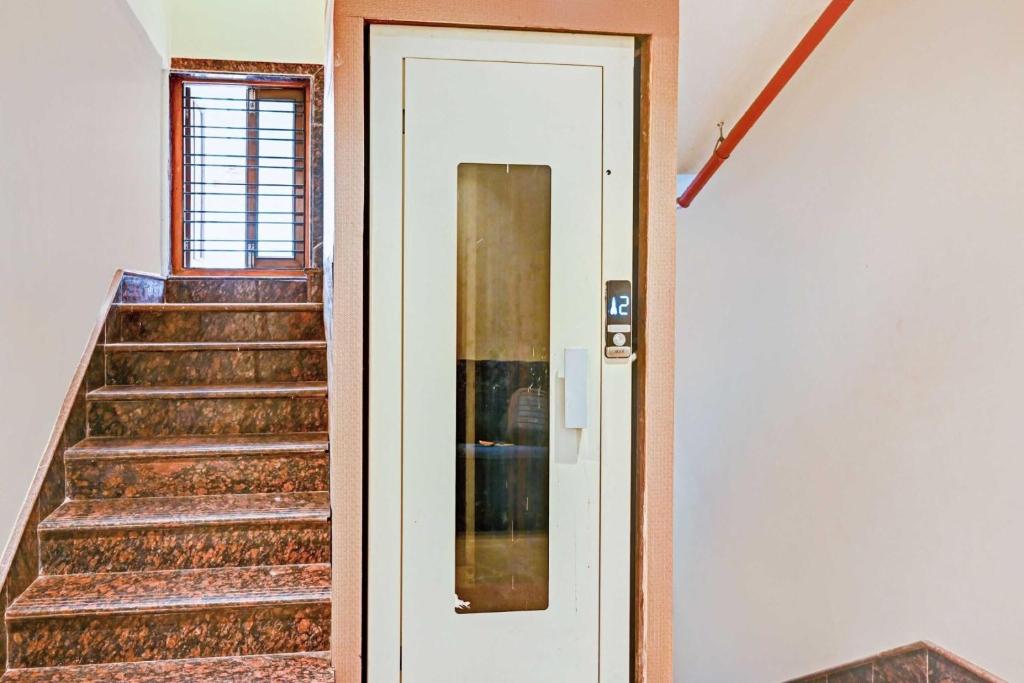 a hallway with stairs and a white door at Hotel O Vrindavan in Kolkata