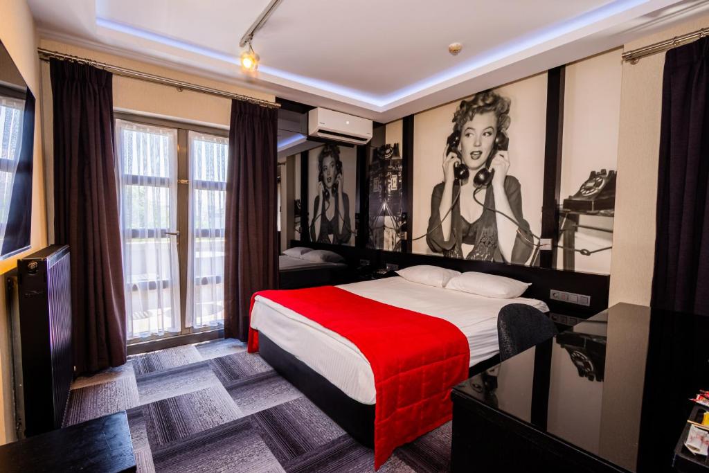 a hotel room with a bed with a red blanket at Maltepe 2000 Hotel in Ankara