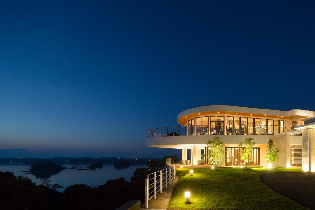 a building with a view of the water at night at Amakusa Tenku No Fune in Kami Amakusa