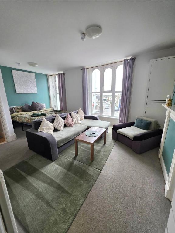 a living room with a couch and a table at Lavish Lounge in Swansea