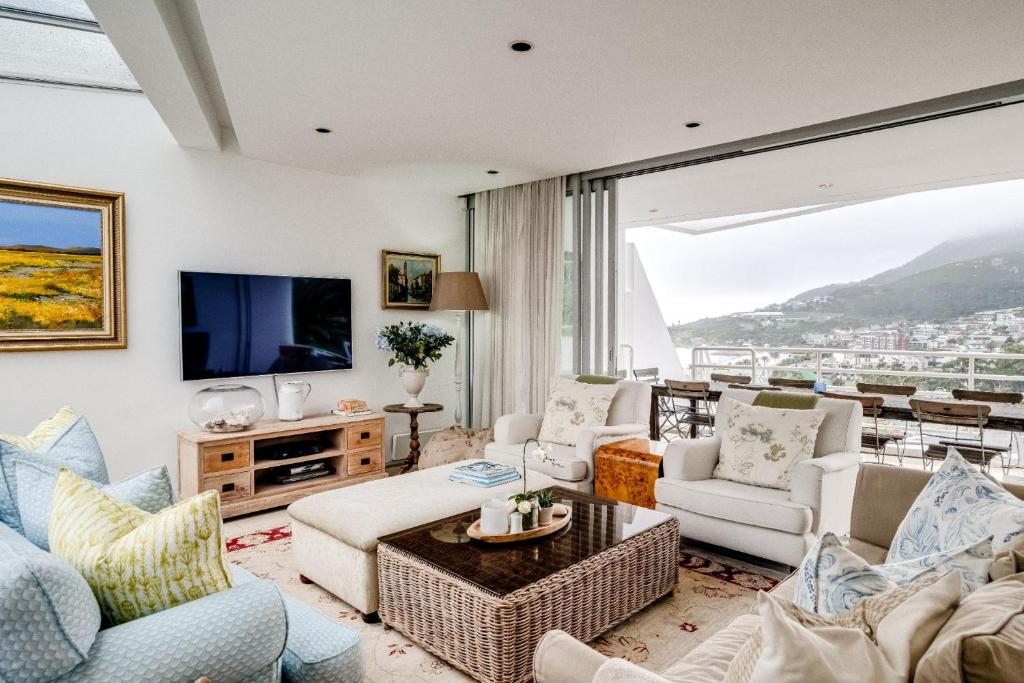 a living room filled with furniture and a large window at Silvertree in Cape Town