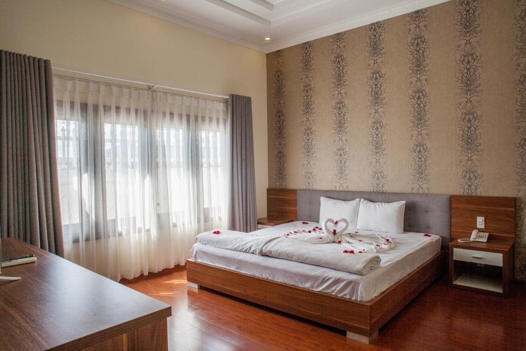a bedroom with a bed with a ribbon on it at Trieu Khang Hotel gần sân bay Cam Ranh near Cam Ranh Airport in Cam Ranh