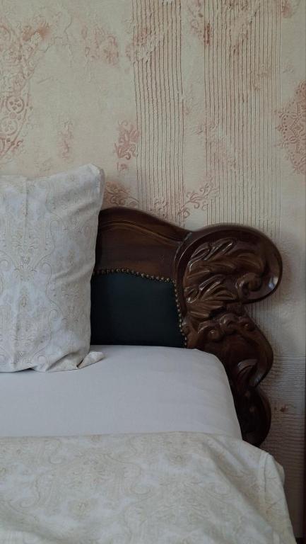 a bed with a wooden head board and a pillow at Hotel Sliv Elite Events in Blatec
