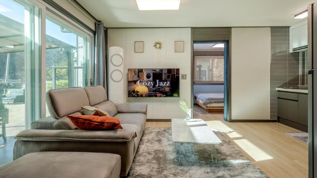 a living room with a couch and a kitchen at Hongcheon Pension 150 in Hongcheon