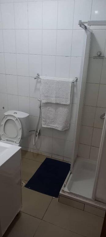 a bathroom with a toilet and towels on the wall at Hotel Gabu Karsa in Gabú