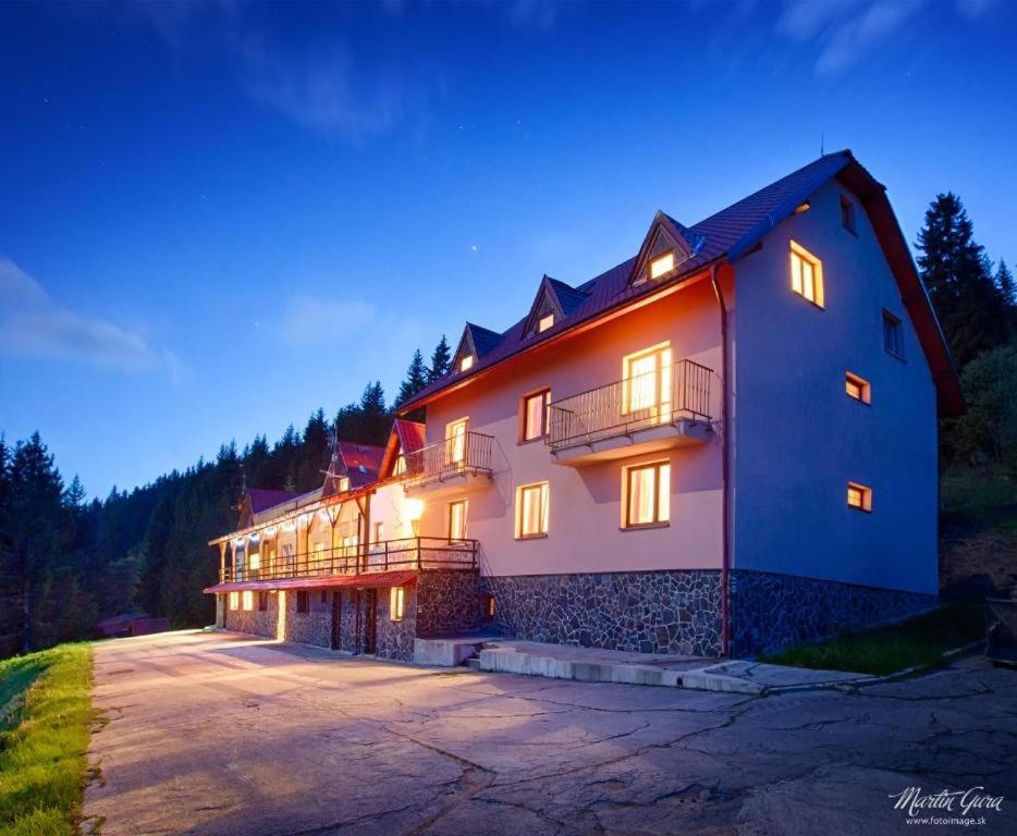 a large house with lights on in the night at Chata Kubínska hoľa in Dolný Kubín