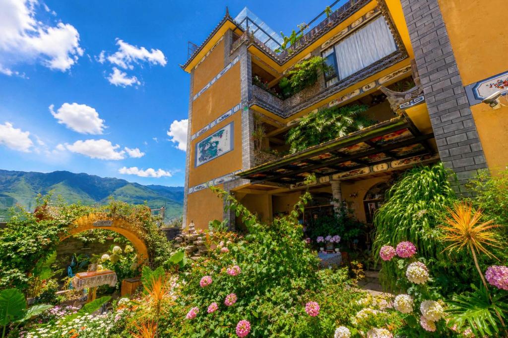a building with flowers in front of it at Sweet August · Boutique Hotel (Dali Erhai) in Dali