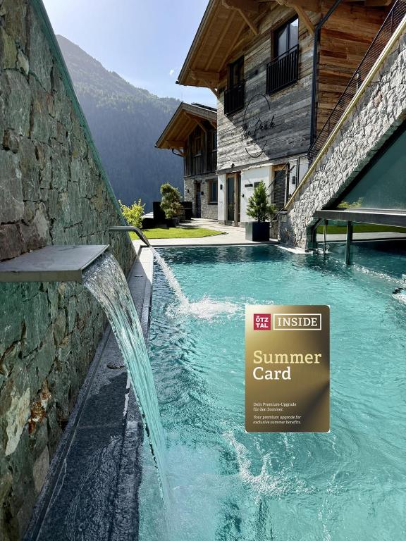 a swimming pool with a sign on the side of a house at The Peak Sölden - Chalets mit Outdoor-Pool in Sölden