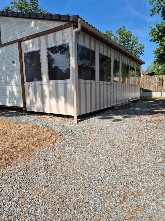 a large building with windows on a gravel driveway at Escapade Calme &Nature in Sulniac