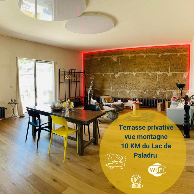a dining room with a table and chairs in a room at Nature loft, calme et confortable in La Murette