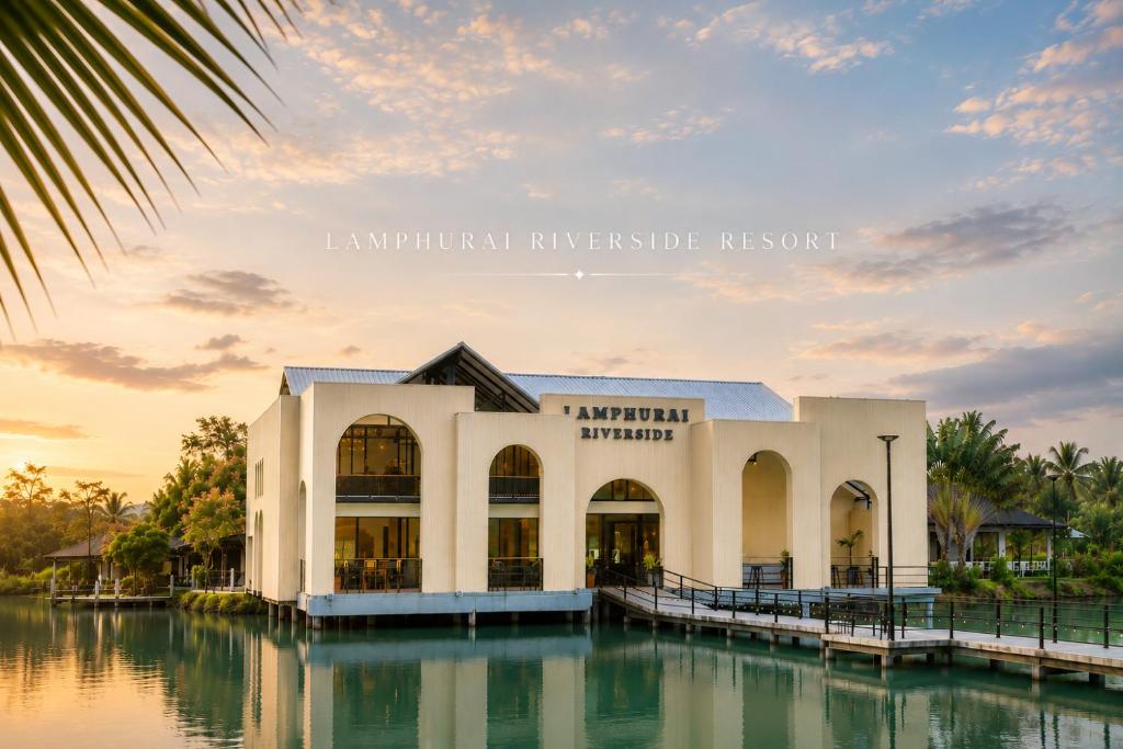 a building on the water at sunset at Lamphurai Riverside Resort and Spa in Trat