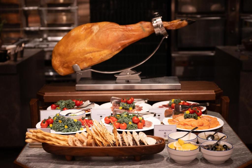 A buffet display centered on a whole roasted turkey and cold platters.