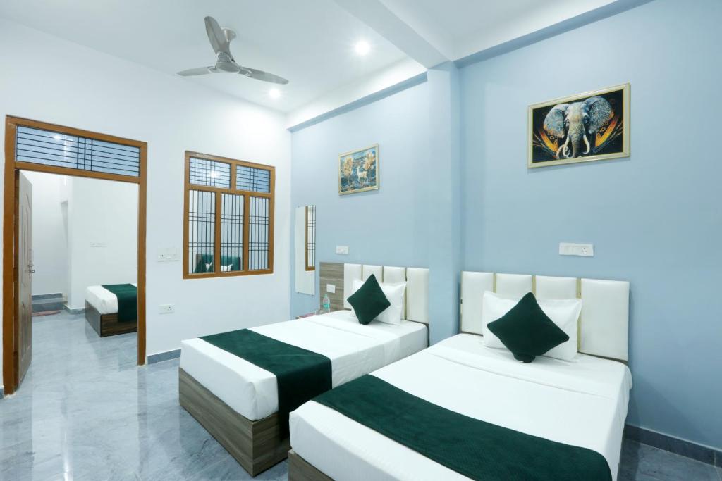 two beds in a room with blue walls at Viraj Guest House in Ayodhya