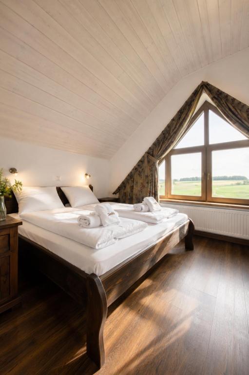 two beds in a room with a large window at Danielówka in Ciemiętniki