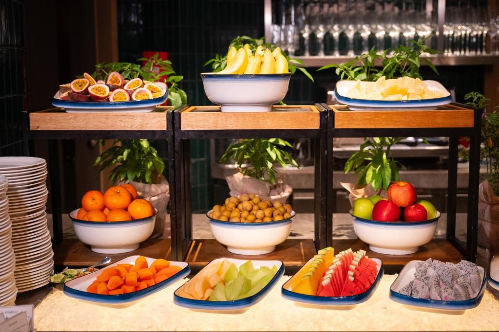 A neatly arranged fruit station with whole and cut tropical produce.