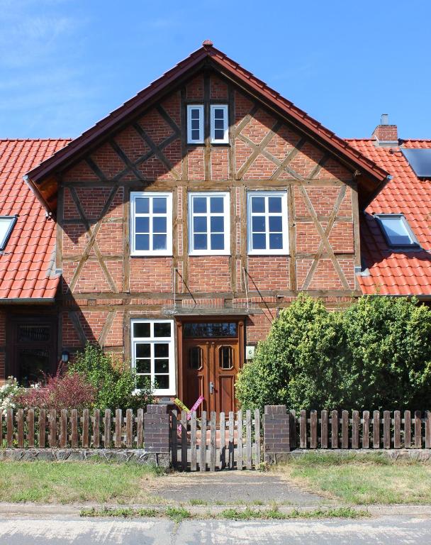 a brown brick house with a wooden fence at Schenkenhof Proitze in Schnega
