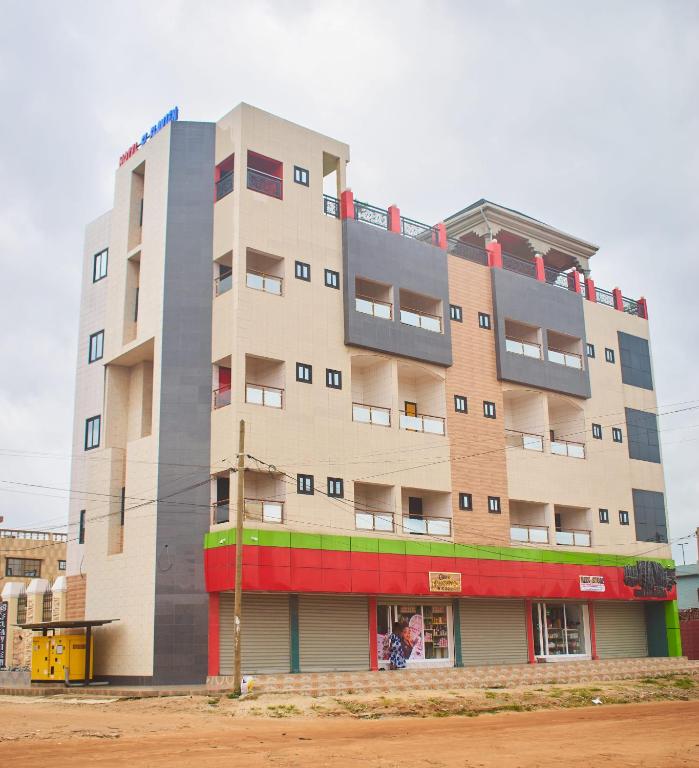 a tall apartment building in front of a street at Hotel St Flavien Lomé in Taméklo
