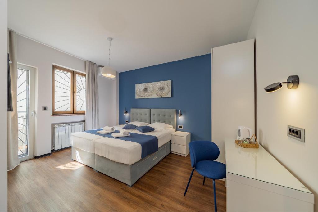 a blue bedroom with a bed and a blue wall at City Code InJoy RENEW in Belgrade