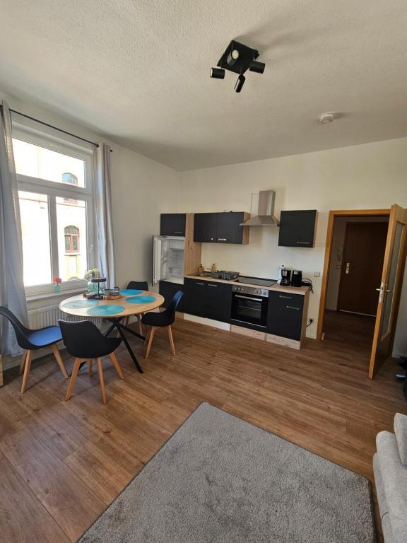 a living room with a table and chairs and a kitchen at Plauen-West in Plauen