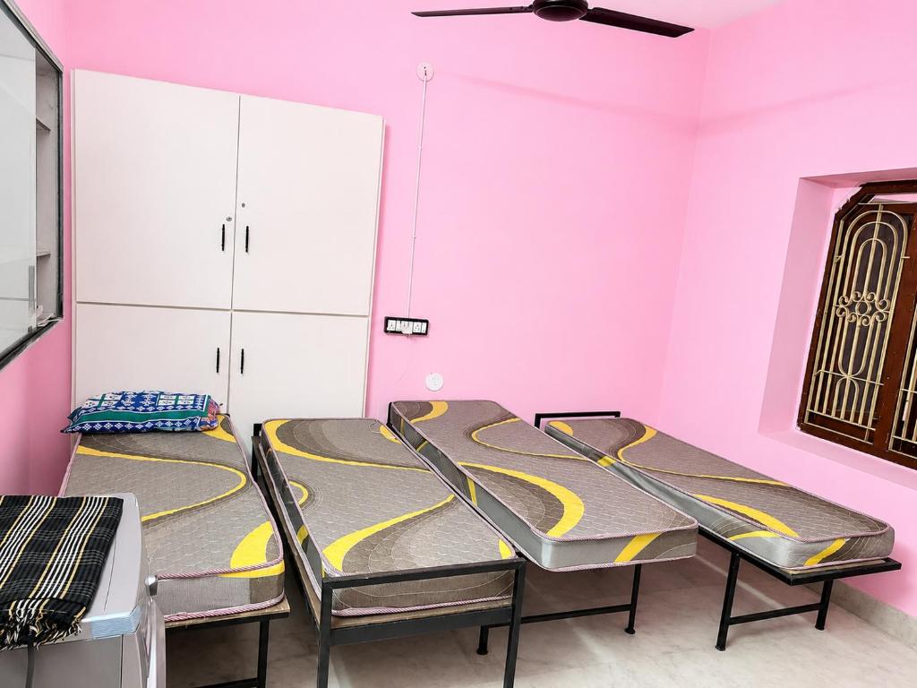 a room with two chairs and a pink wall at Sagar Hotel For Family in Mācherla