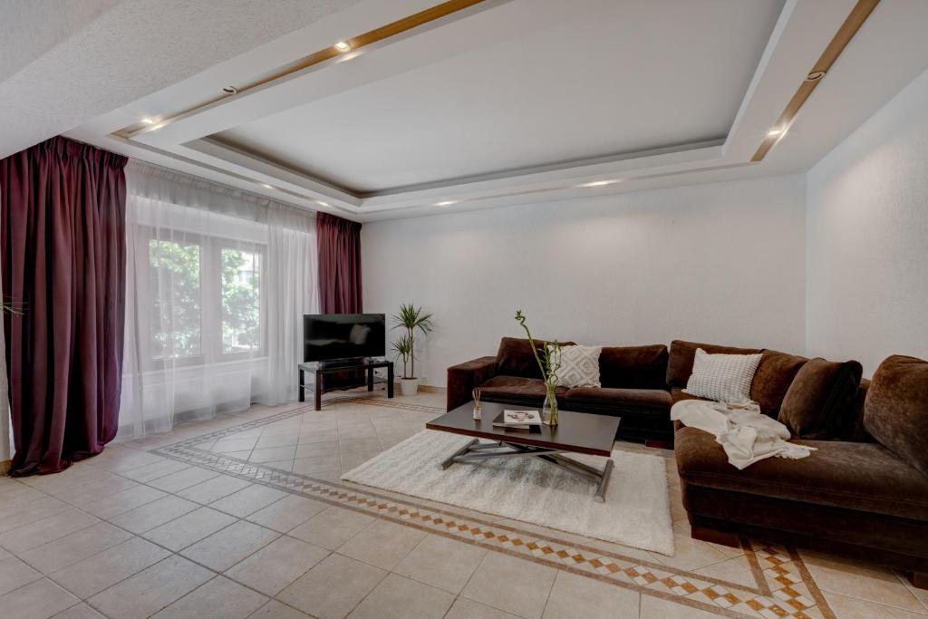 a living room with a couch and a tv at Cozy Apartment Floreasca Park in Bucharest