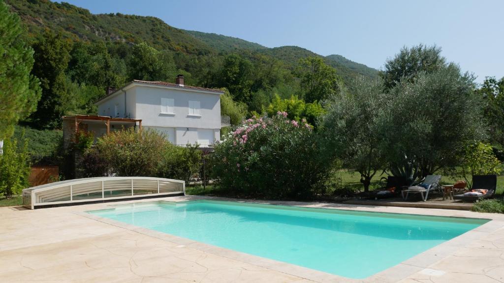 a swimming pool in front of a house at A l'orée du bois - Chambres d'hôtes in Hostun