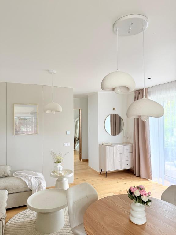 a white living room with a table and chairs at Liiva apartement Kärdla in Kärdla