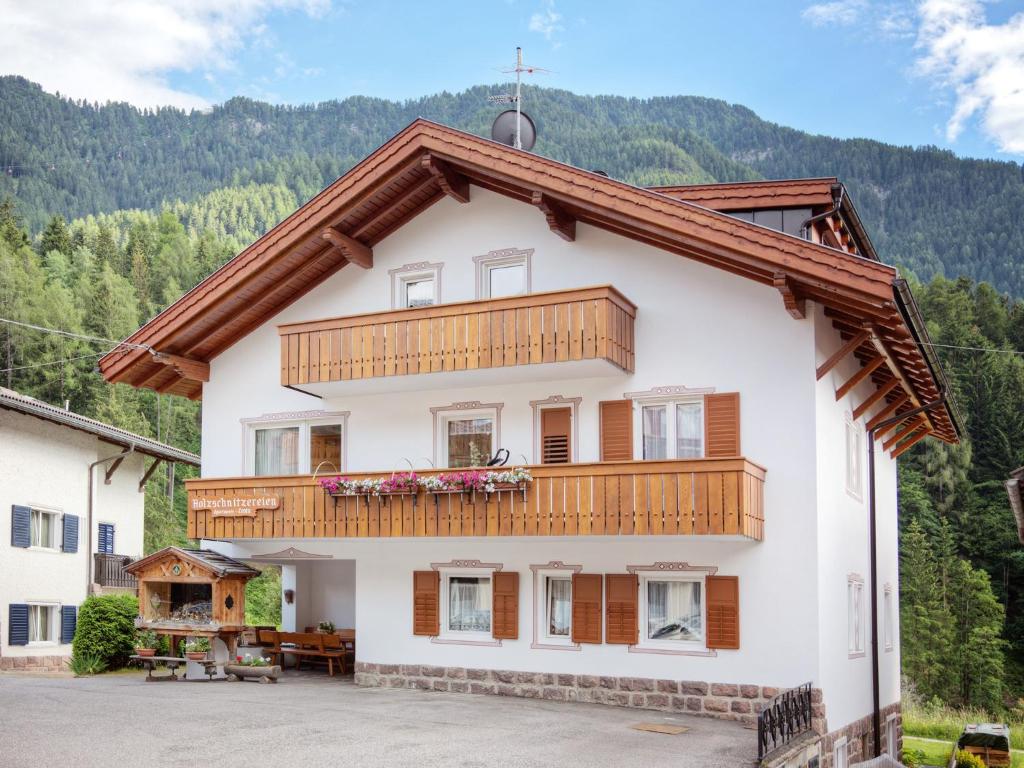 a large white house with a wooden balcony at Villa Costa in Ortisei