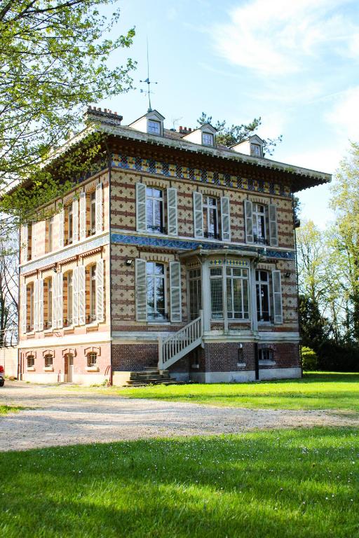 a large brick building with a grassy yard at Les Thibériades in Martin-Église