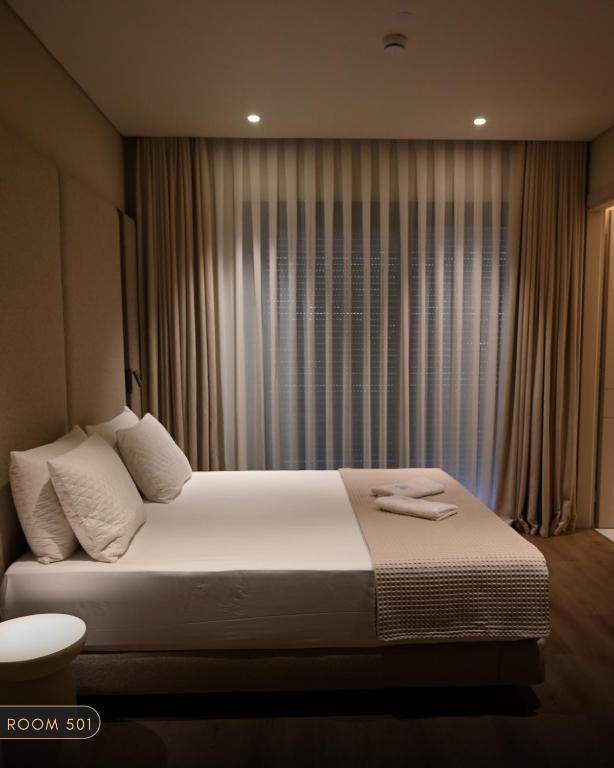a bedroom with a large bed in front of a window at Elmares Hotel in Himare