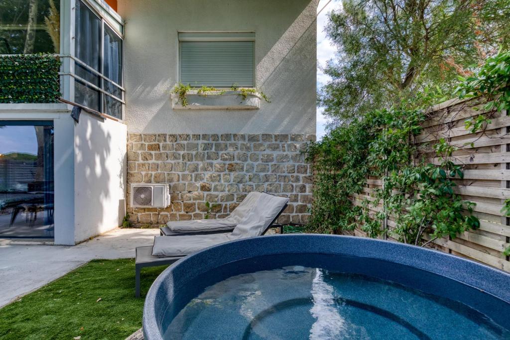 a bath tub in the backyard of a house at Mas Des Jeux - Gîte Grenache in Saint-Laurent-dʼAigouze