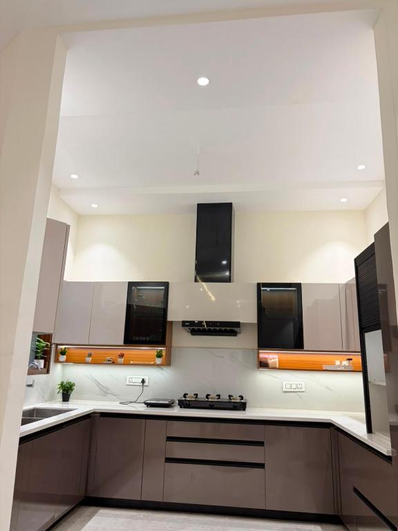 a kitchen with white cabinets and a stove top oven at CRAZZY HOME stay in Chandigarh Airport