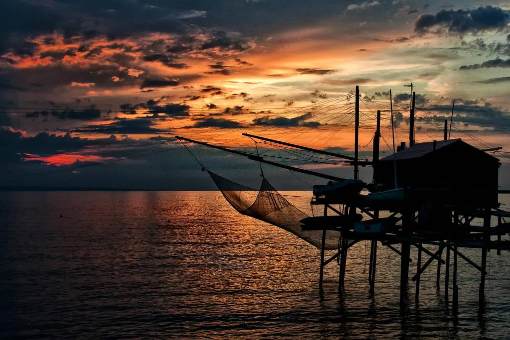 a boat in the water with a sunset in the background at Bed and breakfast Nonna Lucia in Termoli