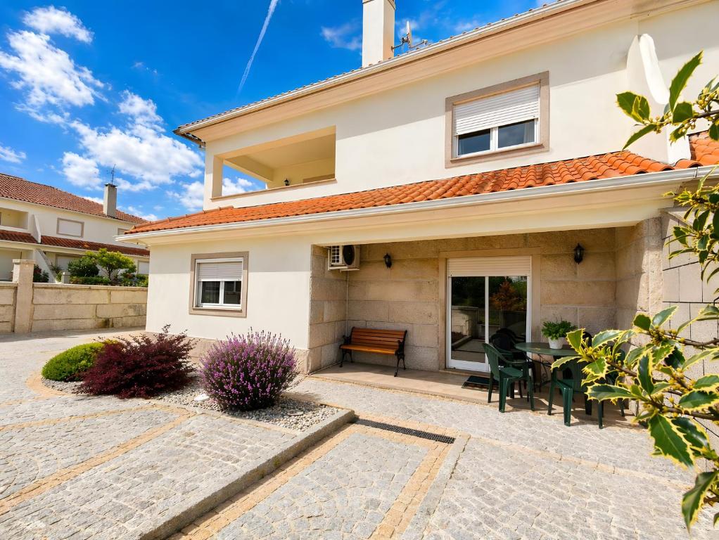 a house with a patio with a table and chairs at Caramulo Valley View in Campo de Besteiros