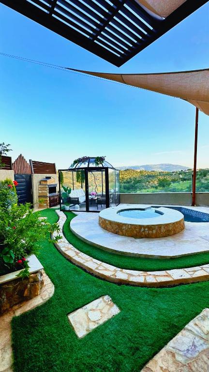 a garden with a circular patio with green grass at Pilar Resort in Bayyūḑah