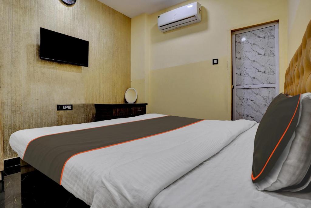 a bedroom with a large bed and a tv on the wall at Hotel O Golden Suites in Turambhe
