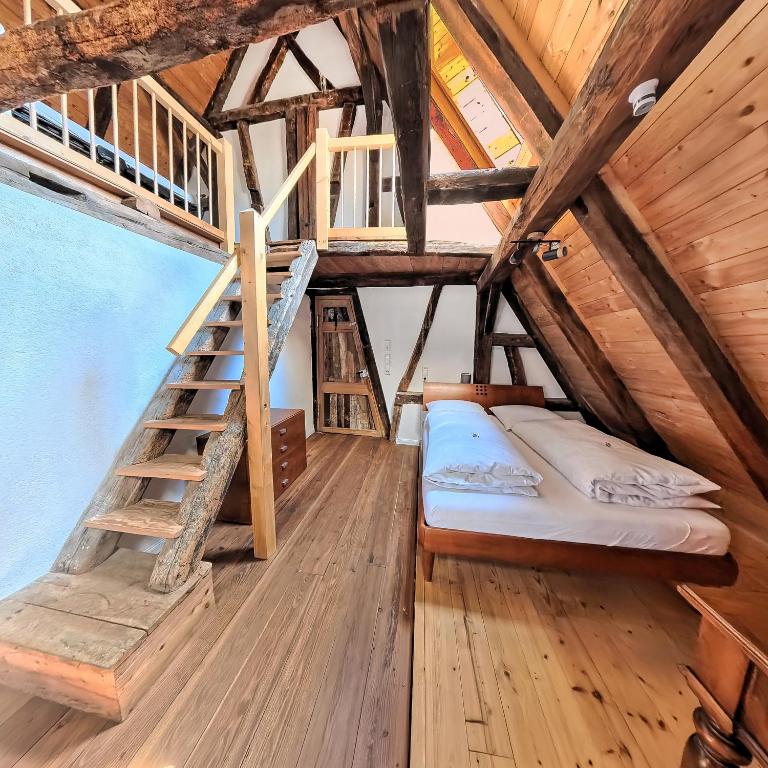 a bedroom with a bunk bed and stairs in a attic at Stevenson House Bed and Breakfast in Oberderdingen