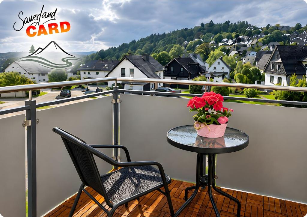 a table with a vase of flowers on a balcony at Komfort-Ferienwohnung gierskopp.pur in Olsberg