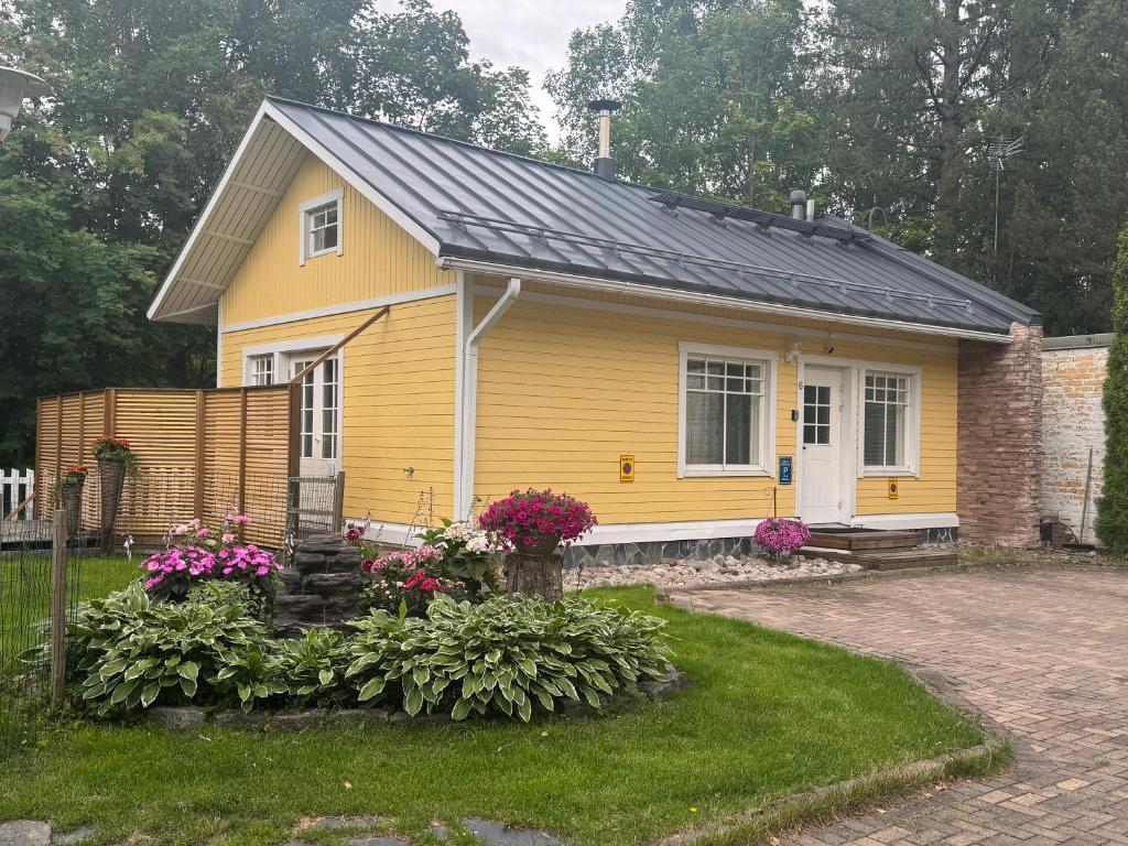 a yellow house with a black roof at Villa Tourula in Jyväskylä