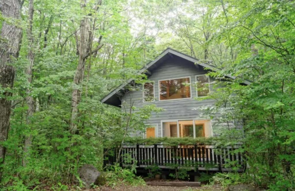 a gray house in the woods with trees at Daruma in Nasu