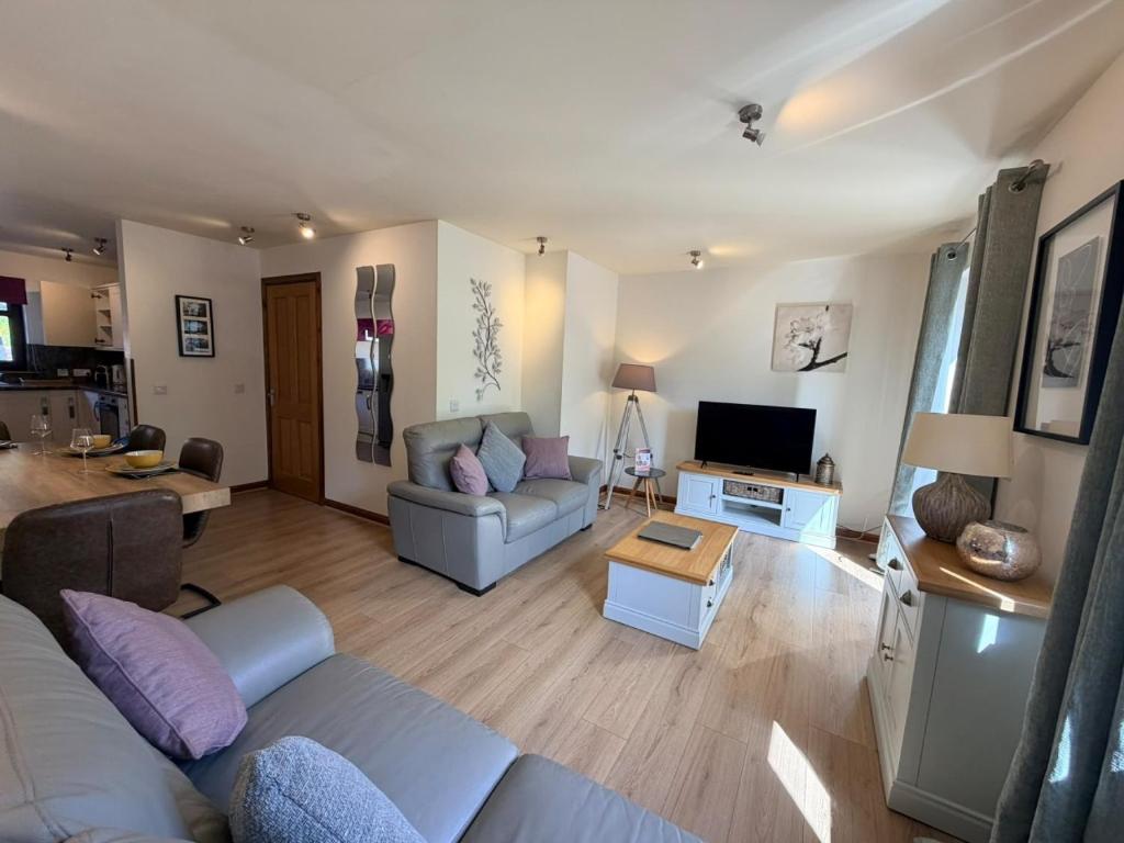 a living room with a couch and a tv at The Galleries No 2 in Spean Bridge