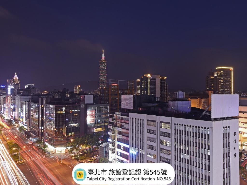 a city skyline at night with buildings and traffic at Eastin Taipei Hotel in Taipei