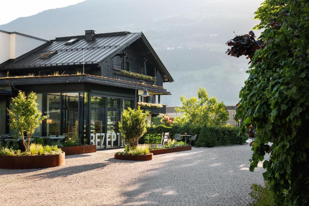 a black building with plants in front of it at Natürlich Hell - Camping & Aparthotel in Fügen