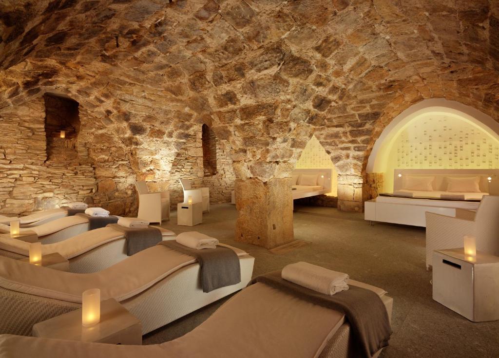 a room with many beds in a stone wall at HYPERION Hotel Dresden Am Schloss in Dresden