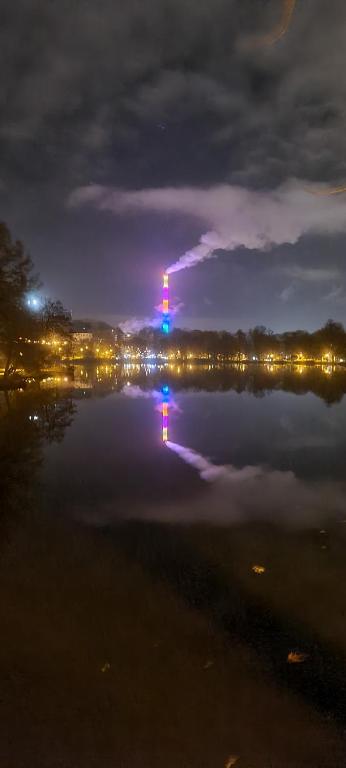 a large body of water with a lit up tower at night at Villa Küchwald in Chemnitz