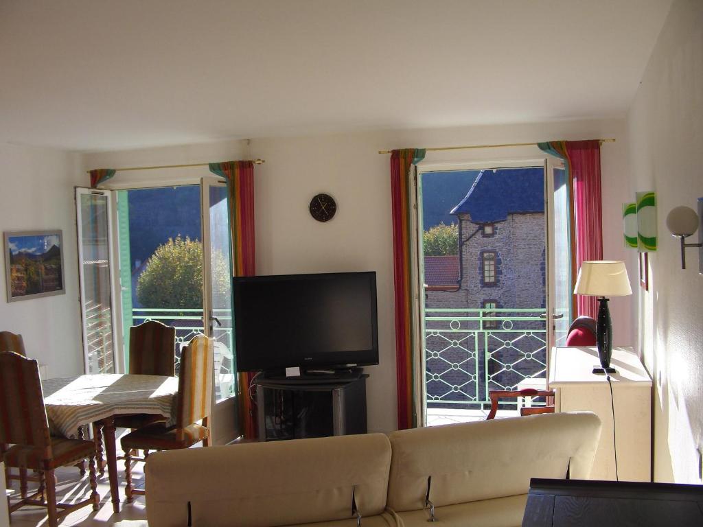 a living room with a couch and a large window at Résidence Espinchal in Massiac